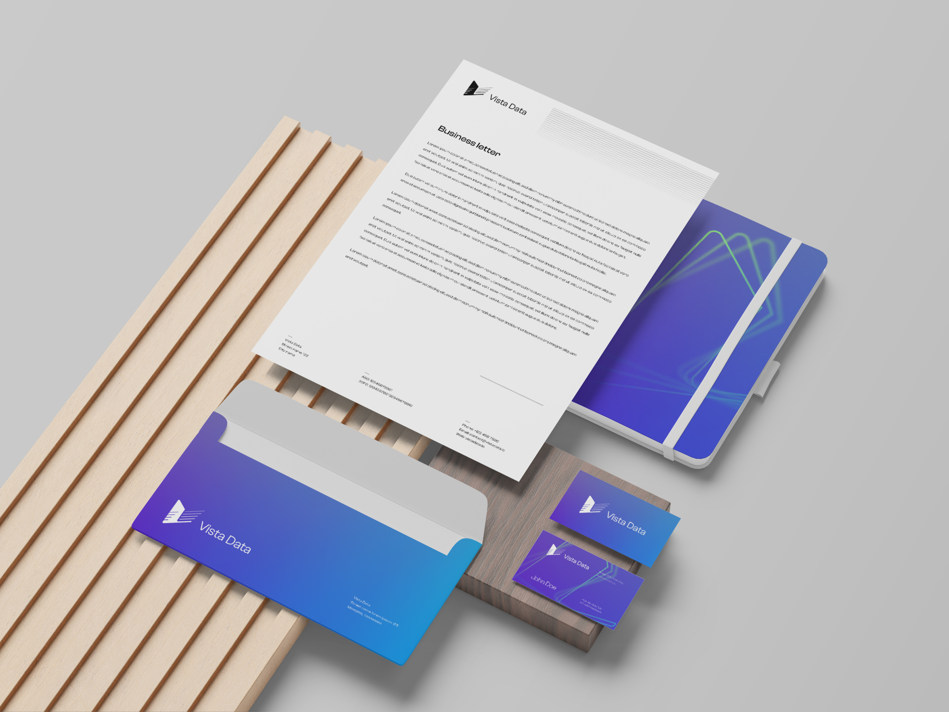 Vista Data stationery set — letterhead, notebook, envelope and business cards on a gradient blue-to-teal backdrop